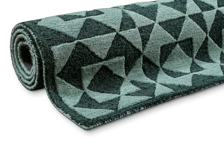 Gerollter Teppich mit geometrischem Dreiecksmuster in Dunkelgrün und Hellgrün.