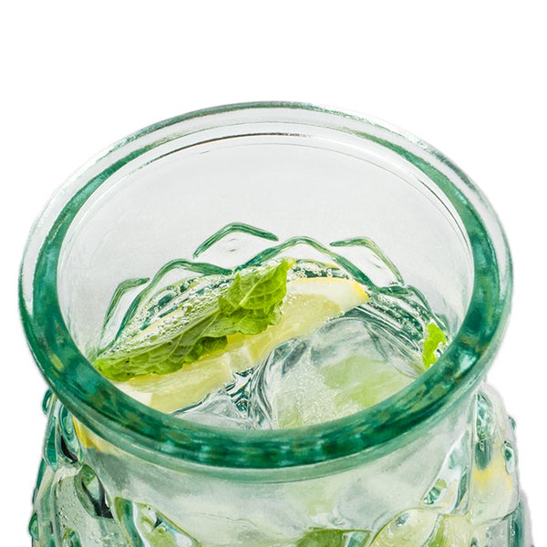 Glas gefüllt mit Eiswürfeln, Zitronenscheiben und Minze