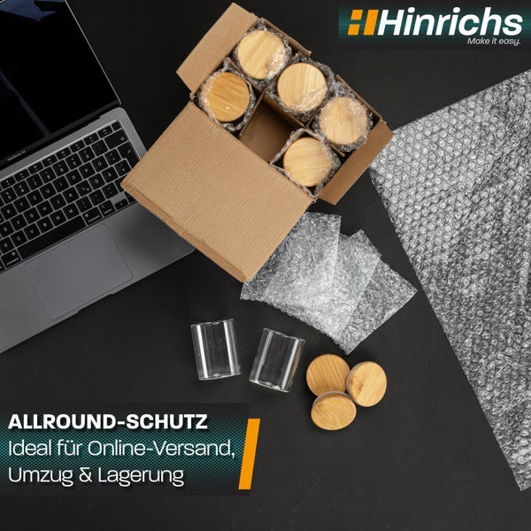 Eine Hand legt ein in Luftpolsterfolie gewickeltes Weinglas in einen Karton, Produkt aus Deutschland, Hinrichs Logo.