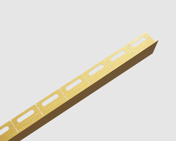 Goldfarbenes Winkelprofil aus Aluminium mit ovalen Aussparungen für den Fliesenabschluss.