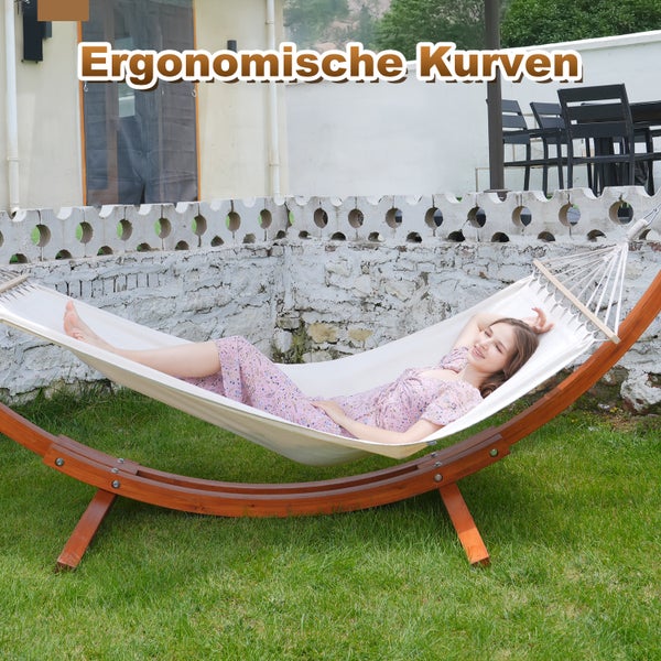 Frau entspannt in Hängematte mit Holzgestell im Garten.