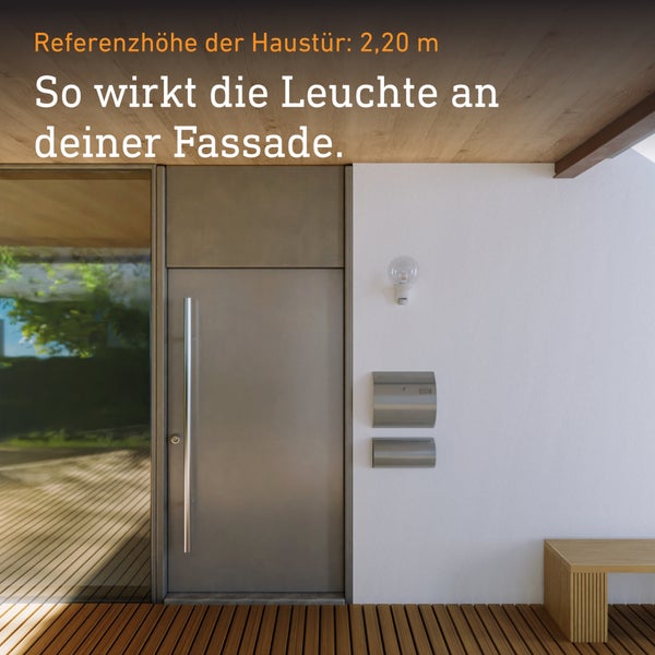 Moderne kugelförmige Außenwandleuchte montiert an einer weißen Hauswand neben einer Tür aus Edelstahl im Eingangsbereich mit Holzdecke.