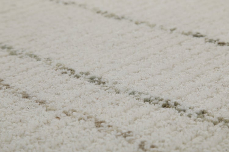 Detailaufnahme der Textur eines weichen Teppichs mit dezentem Streifenmuster.