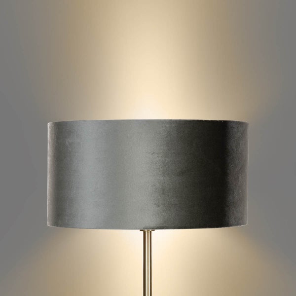 Nahaufnahme einer Stehlampe mit Stoffschirm und Metallsockel