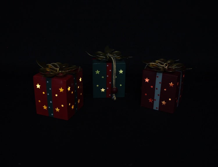 Drei beleuchtete Weihnachtsgeschenke aus Metall als dekorative Weihnachtsbeleuchtung mit Sternenausstanzungen und Schleifenverzierung