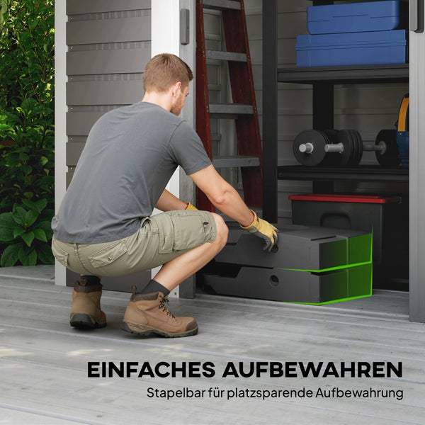 Ein Mann verstaut stapelbare Aufbewahrungsboxen in einem organisierten Gartenhaus mit Regalsystem, Werkzeug und Leiter.