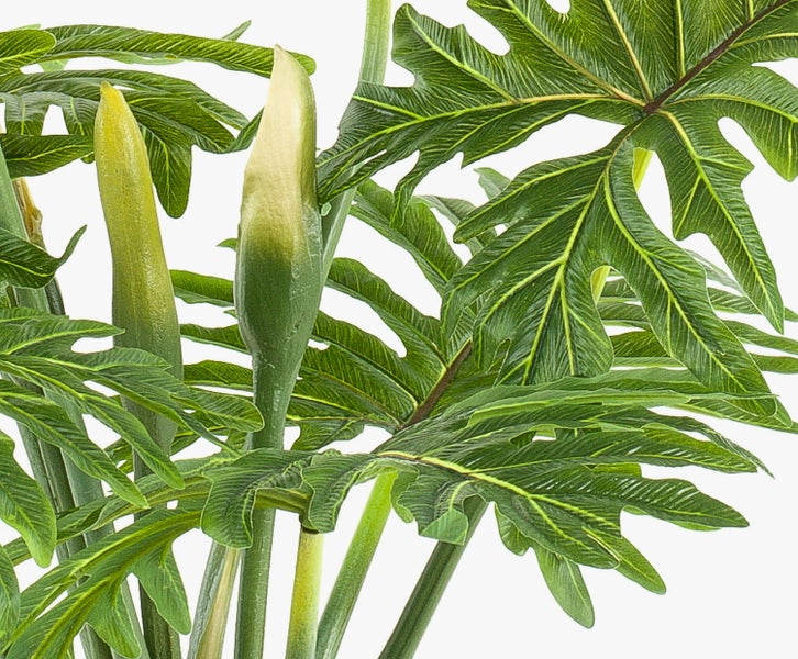 Nahaufnahme einer künstlichen Bambuspflanze mit grünen Blättern und dünnen Stielen.