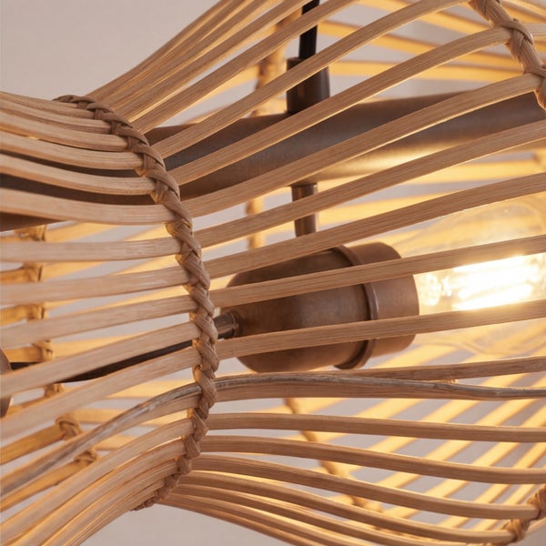 Nahaufnahme einer Pendelleuchte mit einem Schirm aus geflochtenem Rattan und einer sichtbaren Glühbirne im Inneren.