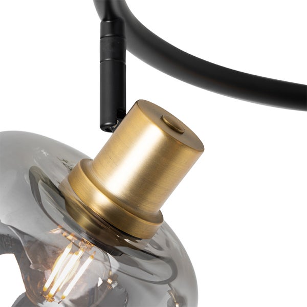 Nahaufnahme einer Deckenleuchte mit Messingfassung, rauchfarbenem Glasschirm und sichtbarem LED-Filament-Leuchtmittel.