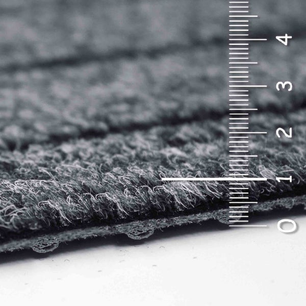 Detailaufnahme eines grauen Teppichs mit Messskala zur Darstellung der Florhöhe