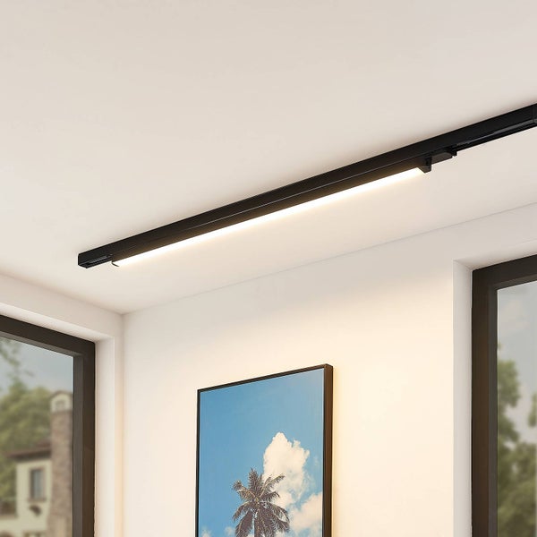 Modernes schwarzes LED-Schienensystem mit Lichtleiste an der Decke in einem hellen, organisierten Raum mit Wandbild und Fenstern.