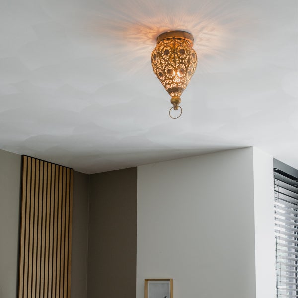 Deckenleuchte mit orientalischem Muster beleuchtet einen Raum.