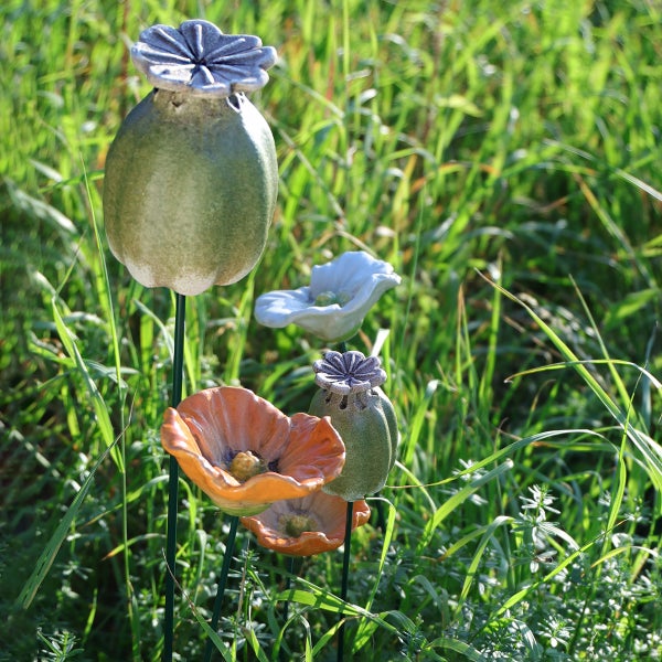 Dekorative Mohnblumen aus Keramik als Gartendekoration.