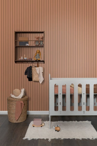 Kinderzimmer mit Kinderbett, Wandregal und Spielzeug vor gestreifter Tapete