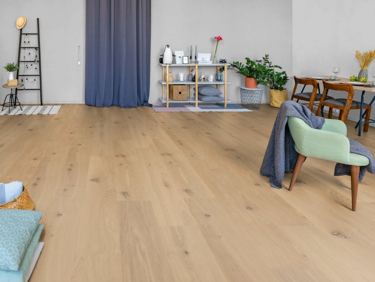 Helles Eichenparkett in einem modern eingerichteten, geräumigen Wohnzimmer mit Sessel, Esstisch und Regalen.