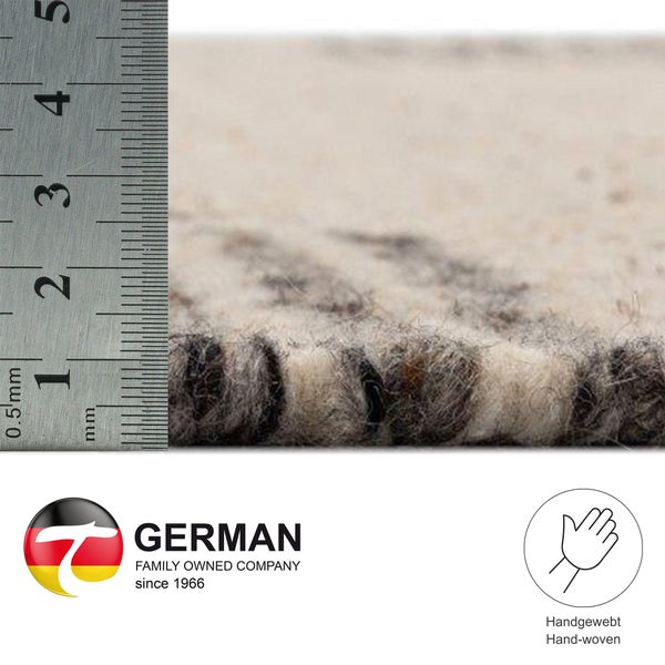Detailaufnahme Teppich mit Messskala, Label Familienunternehmen seit 1966, Siegel Handarbeit