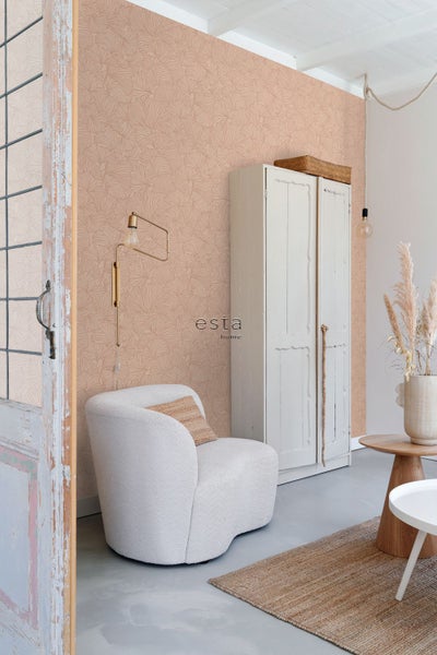 Wohnzimmer mit Vliestapete mit Ginkgo Blatt Muster, kombiniert mit einem Sessel aus Boucle Stoff, Vintage Schrank und Esta Home Logo.