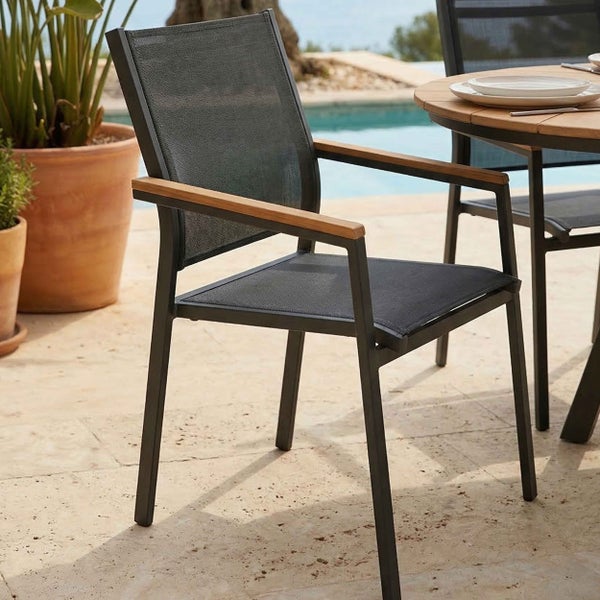 Gartenstuhl mit Metallgestell, Textilbespannung und Holzarmlehnen in einer hellen Außenszene am Pool neben einem Holztisch.