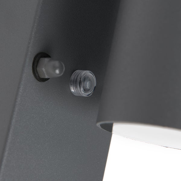 Nahaufnahme einer Wandleuchte mit Sensor an einem anthrazitfarbenen Metallgehäuse.