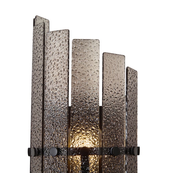 Moderne Wandleuchte mit strukturierten Glaslamellen in kaskadierender Anordnung und integrierter Lichtquelle.
