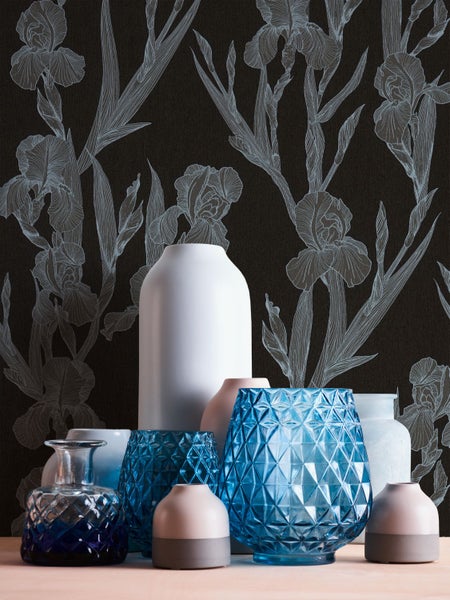Verschiedene Vasen vor einer floralen Tapete