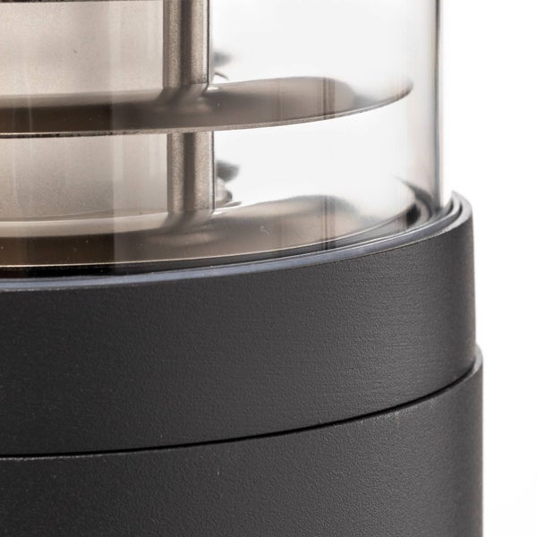 Detailansicht einer Außenleuchte mit transparentem Gehäuse und dunklem Sockel, Innenleben mit Lamellen aus Edelstahl.