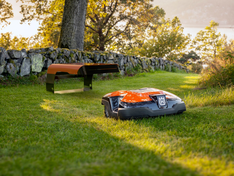 Husqvarna Mähroboter auf einer Rasenfläche mit Ladestation