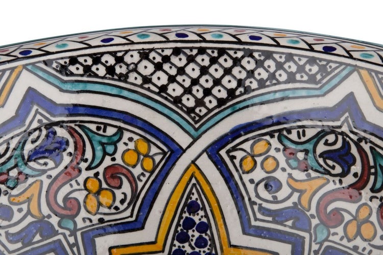 Nahaufnahme einer kunstvoll bemalten Keramikschüssel mit floralen und geometrischen Mustern