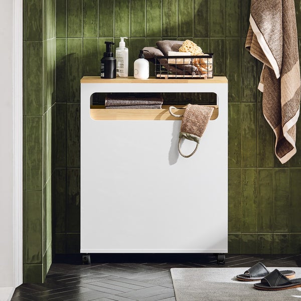 Badezimmer Szene mit einem weißen Unterschrank mit Holzplatte, Handtüchern und Pflegeprodukten