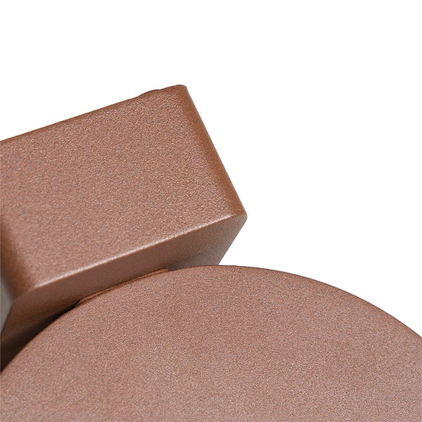 Detailaufnahme einer braunen Wandleuchte aus Metall mit strukturierter Oberfläche.