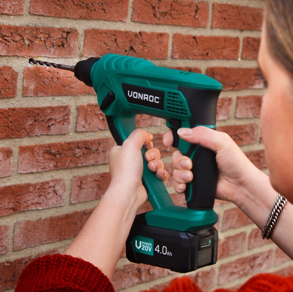 Vonroc Akku-Bohrhammer 20 Volt wird an einer Ziegelwand verwendet.
