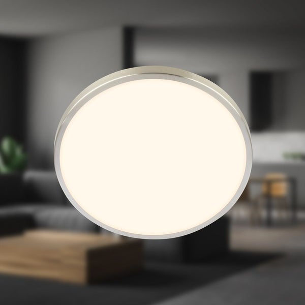 Runde LED-Deckenleuchte mit warmweißem Licht und silberfarbenem Rahmen in einer modern eingerichteten Wohnumgebung.