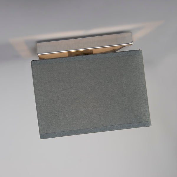 Rechteckige Wandleuchte mit grauem Stoffschirm und Basis aus gebürstetem Metall.