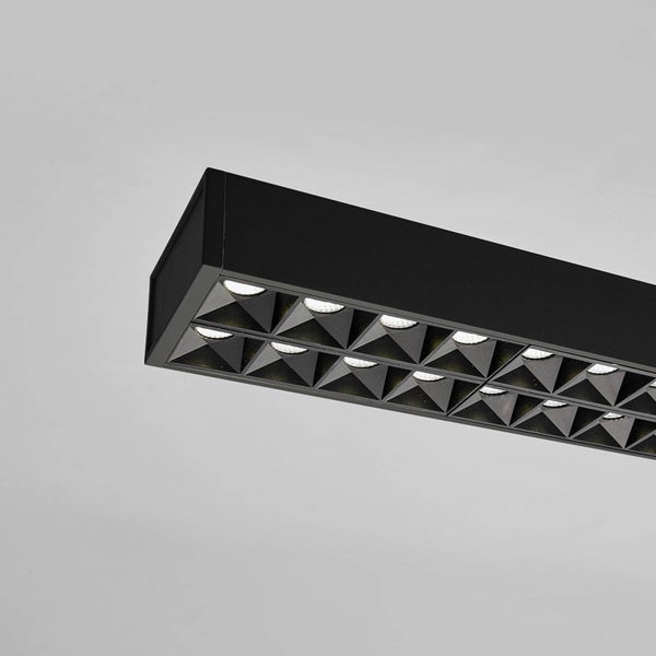 Schwarze lineare LED-Leuchte mit pyramidenförmigem Raster und integrierten Leuchtmitteln.