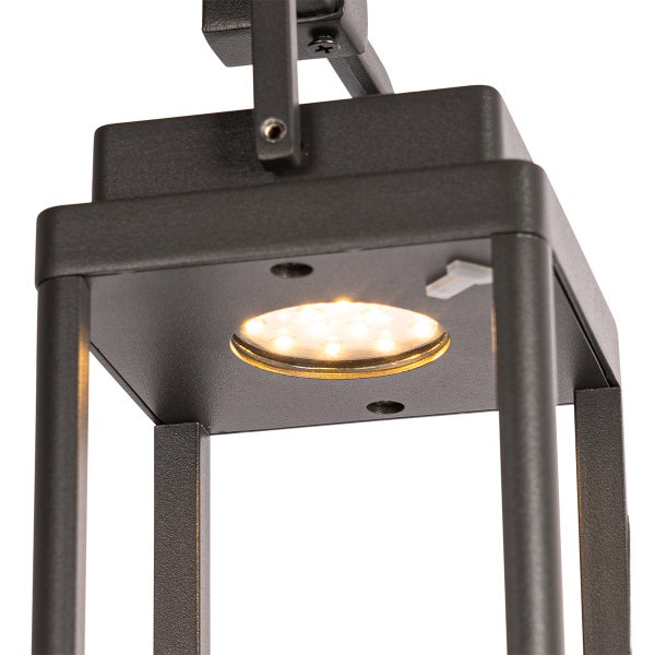 Detailansicht einer quadratischen schwarzen Außenleuchte aus Metall mit eingeschaltetem LED-Leuchtmittel.