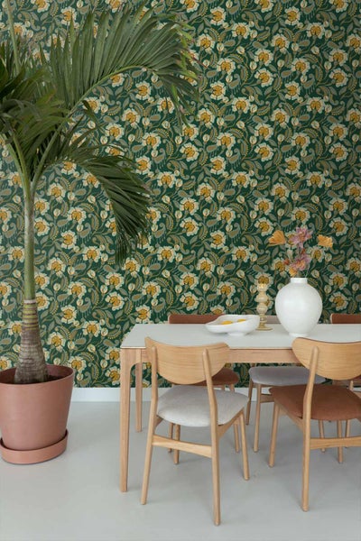 Moderner Essbereich mit floral gemusterter Tapete, einem Holztisch mit weißer Platte, Holzstühlen und einer großen Palme im Topf.