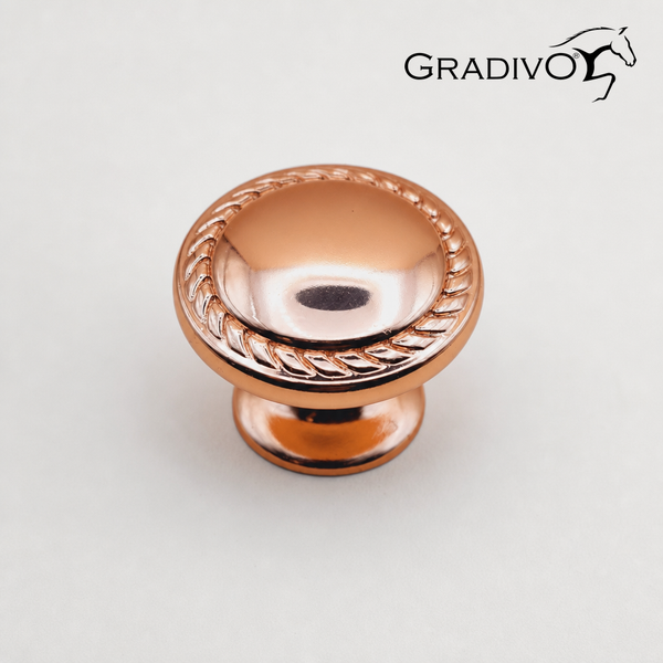 Runder Möbelknopf von Gradivo aus Metall mit geflochtenem Rand in Kupferoptik und Gradivo Logo.