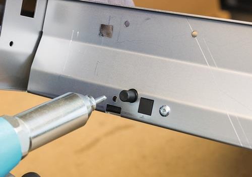 Detailansicht einer Metallkonstruktion mit Heissluftpistole bei der Bearbeitung.