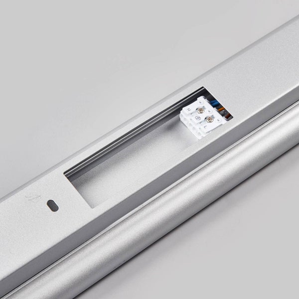 Detailaufnahme einer silbernen Unterbauleuchte mit integrierter Anschlussklemme für die elektrische Installation.