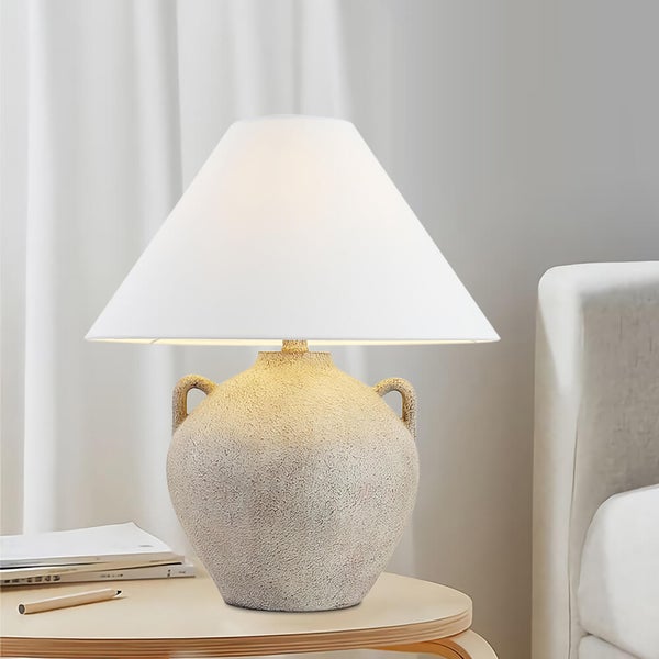 Dekorative Tischlampe mit weißem Lampenschirm und Amphoren-Basis auf einem Beistelltisch