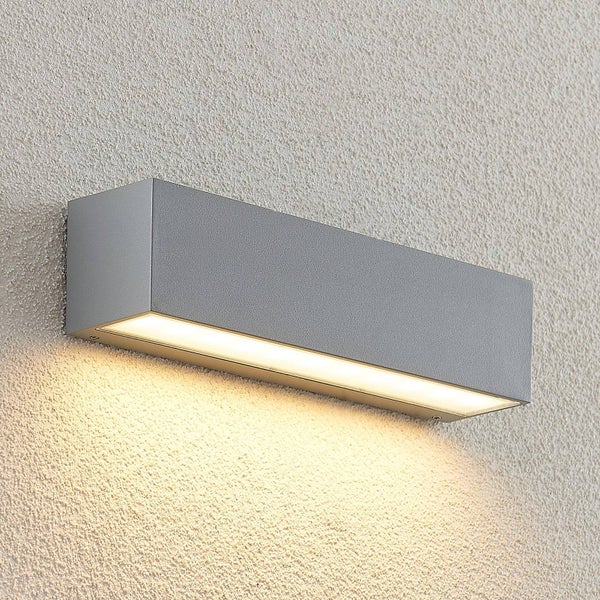 Rechteckige Außenwandleuchte aus Metall, montiert an einer Wand, der Lichtkegel ist nach unten gerichtet.