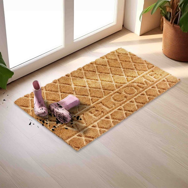 Fußabstreifer mit Willkommensaufschrift, daneben Gummistiefel