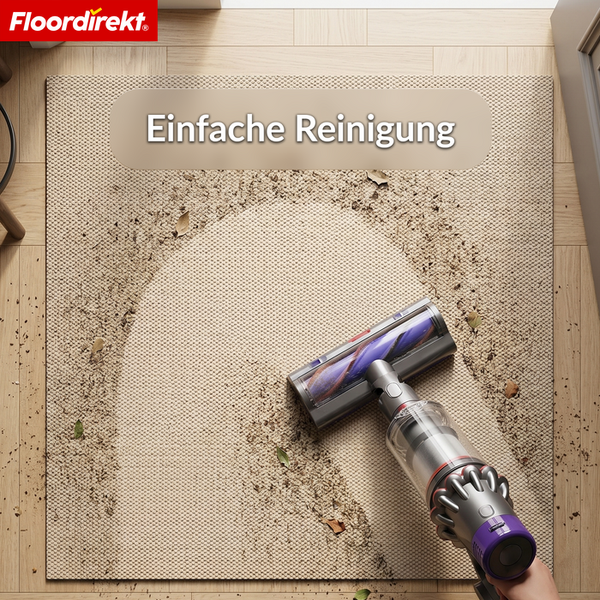 Floordirekt Logo. Handstaubsauger saugt Schmutz von einer strukturierten Bodenmatte auf Holzboden. Text Einfache Reinigung.