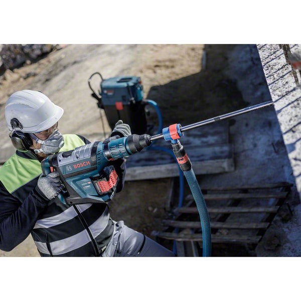 Handwerker bohrt mit einem Bohrhammer mit Staubabsaugung von Bosch in eine Wand.