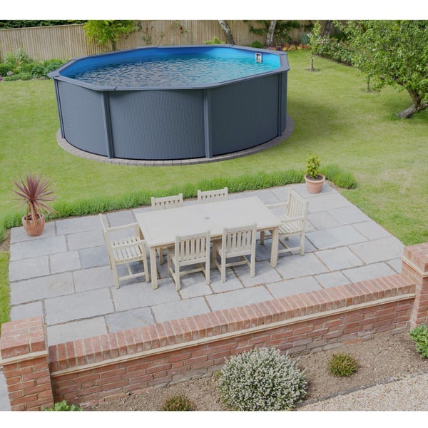 Gartenansicht mit Pool, Esstisch und Stühlen auf einer Terrasse.