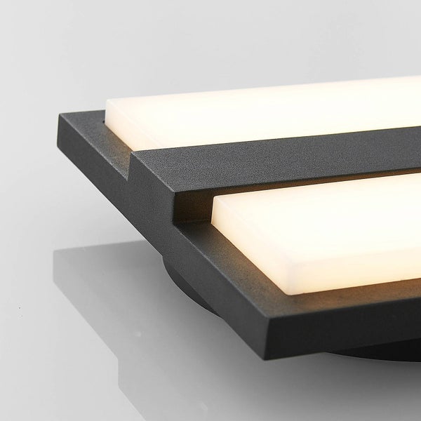 Detailansicht einer modernen LED-Leuchte mit dunklem Metallrahmen und rechteckigen, weiß leuchtenden Diffusoren.