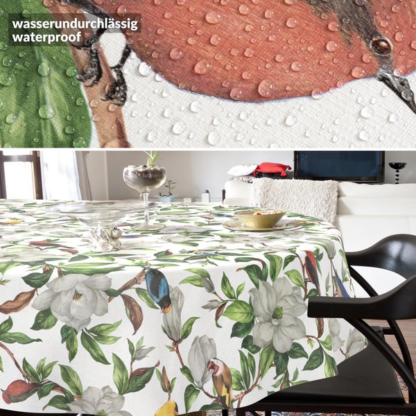 Runde Tischdecke mit Vogel- und Magnolienmuster, wasserabweisende Oberfläche mit abperlenden Wassertropfen.