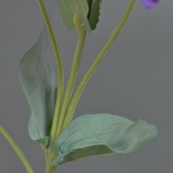 Nahaufnahme eines grünen Stiels einer Kunstpflanze mit texturierten grünen Blättern.