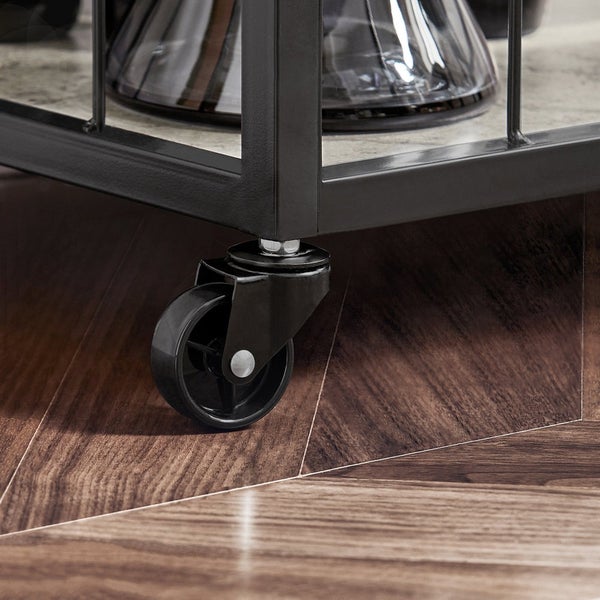 Detailaufnahme eines Servierwagens mit Rollen auf einem Holzboden