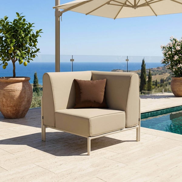 Beiges Eckmodul Lounge-Sessel mit Kissen auf einer Terrasse am Pool mit Meerblick unter einem Sonnenschirm.